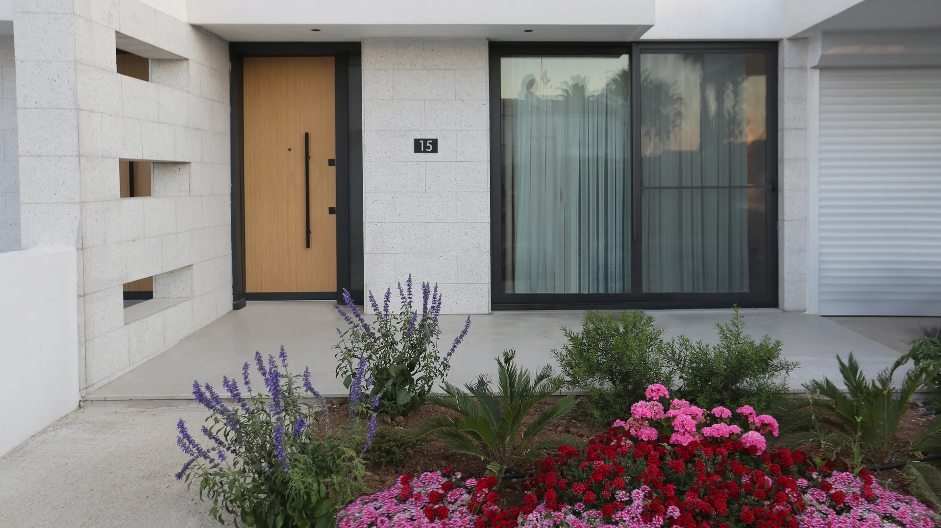 Azure villa entrance with a flower bed