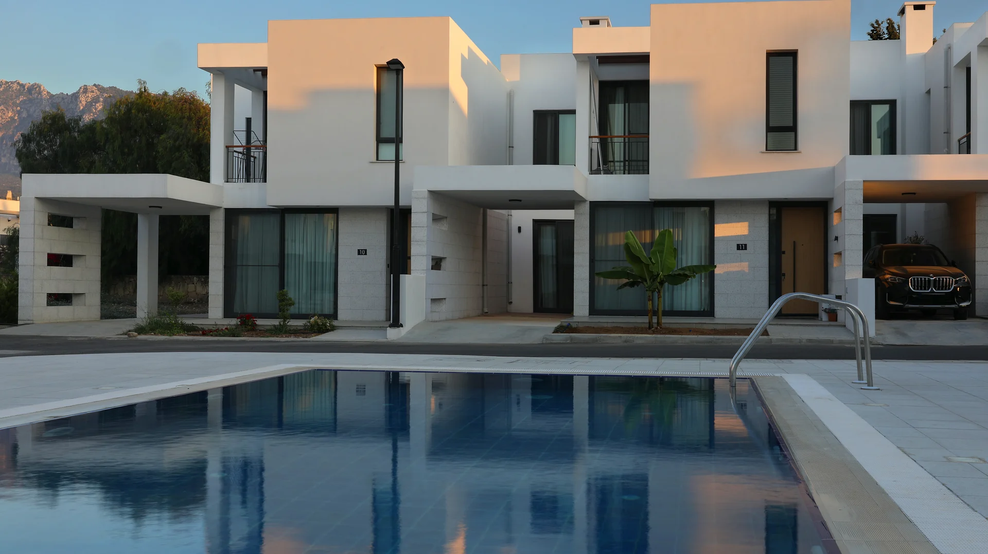 Azure villas around the shared pool at dusk