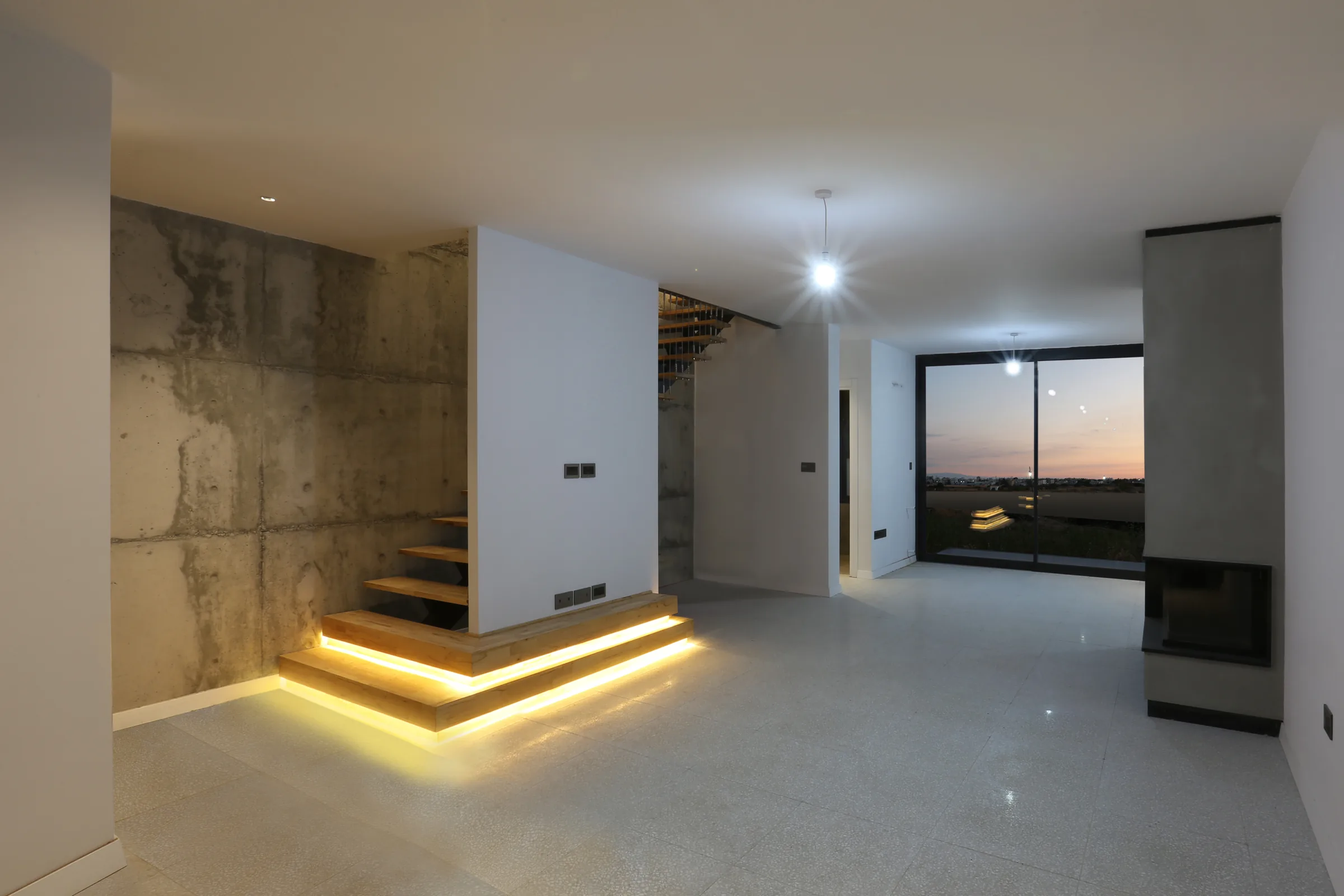 Living area and lit staircase in a Cordia Twins home