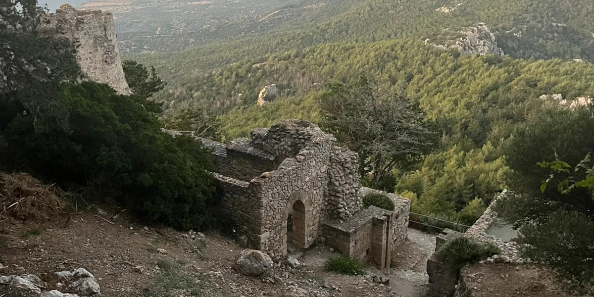 Stone castle ruins on a forested ridge overlooking the northern coast of Cyprus